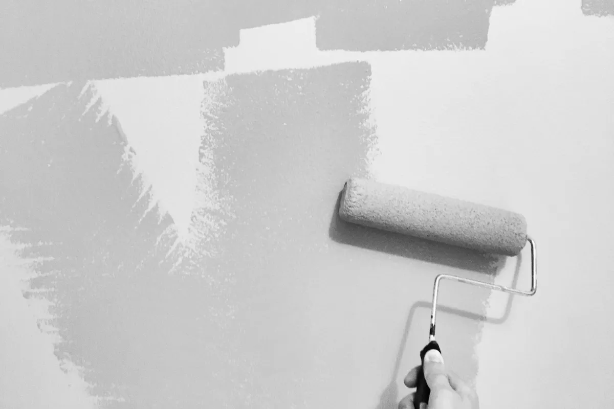 Decorator painting an interior wall with a roller